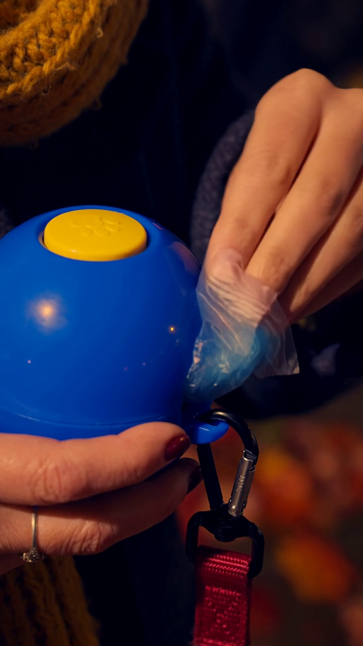 Pulling a waste bag from the Yippy Light dispenser
